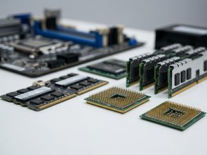 Various computer hardware components, including a motherboard, CPU, and RAM sticks, laid out on a table.